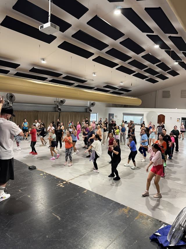 Participants following a step across the floor during a DJ Zumba class.