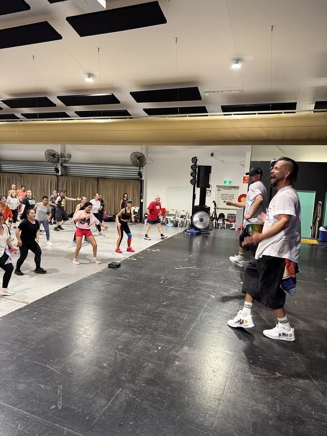 An instructor calling out the next move with the class following behind.