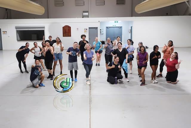 Class members posing together in the sports hall at the end of a class.